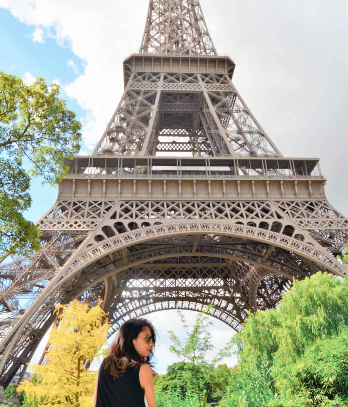 solo female traveller in paris under the eiffel tower