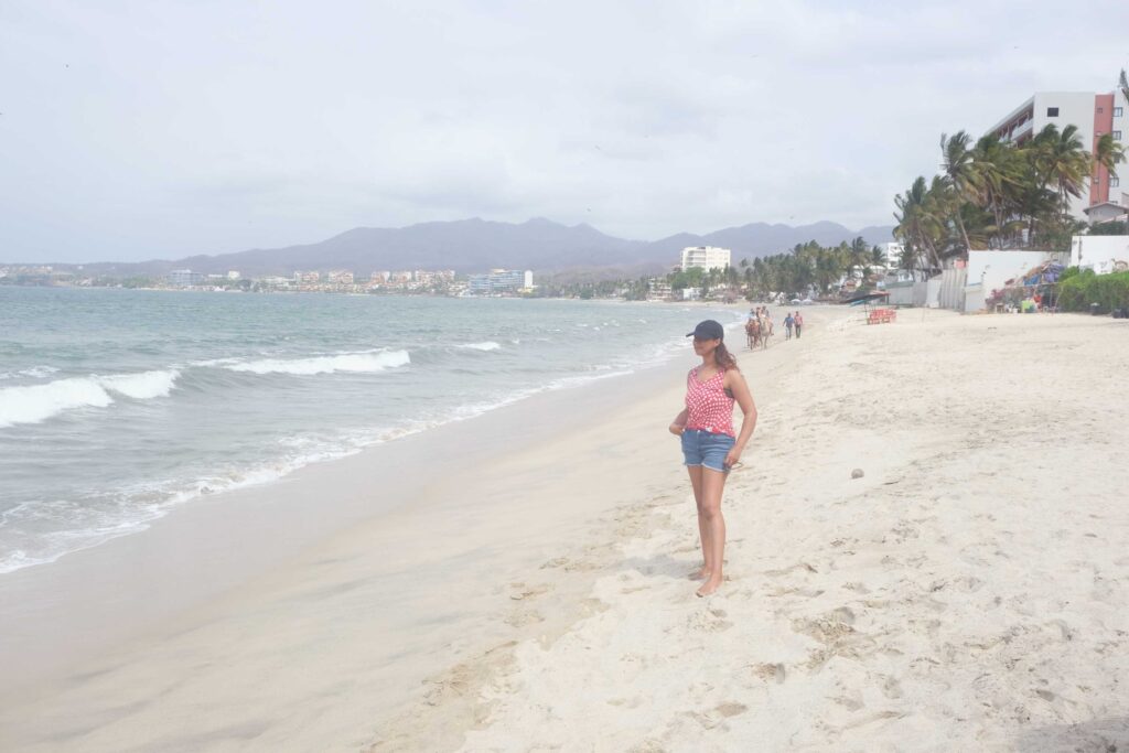 girl standing in an empty sandy beach