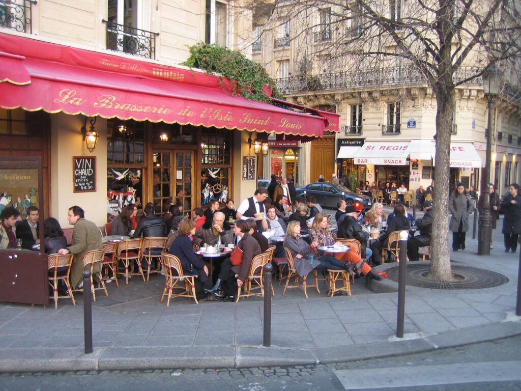  people watching from a cafe terrace is a great way to spend Solo travel in Paris