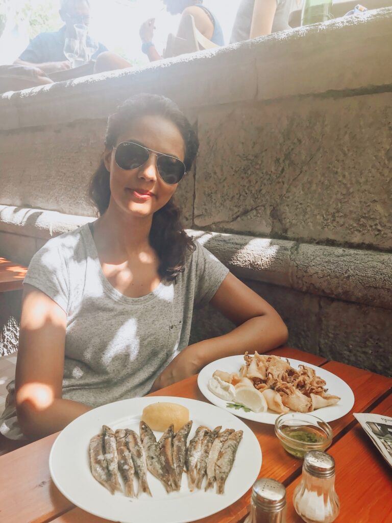 girl smiling, plates of fish and sardines