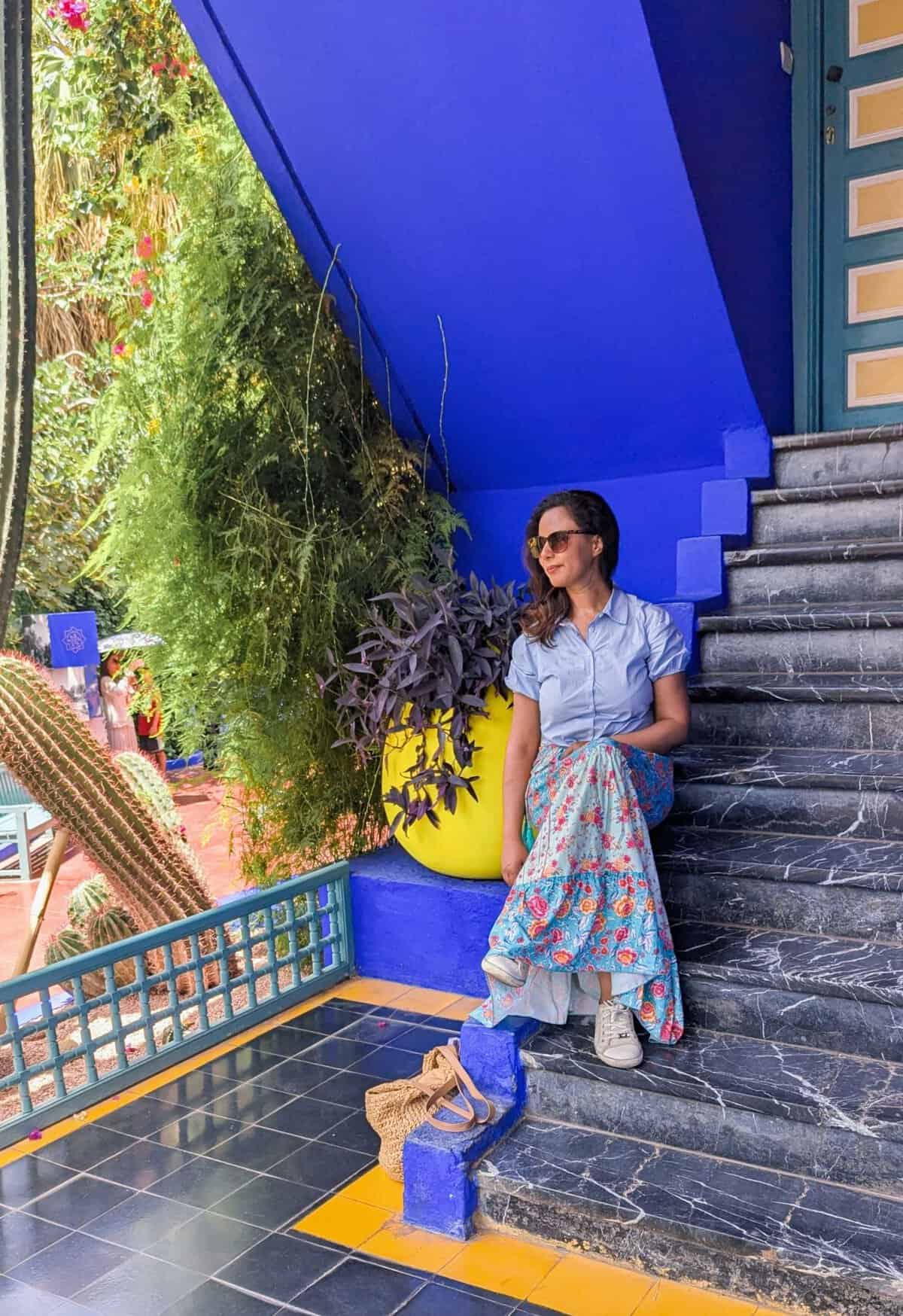 girl sitting on marble stairs with indigo blue wall