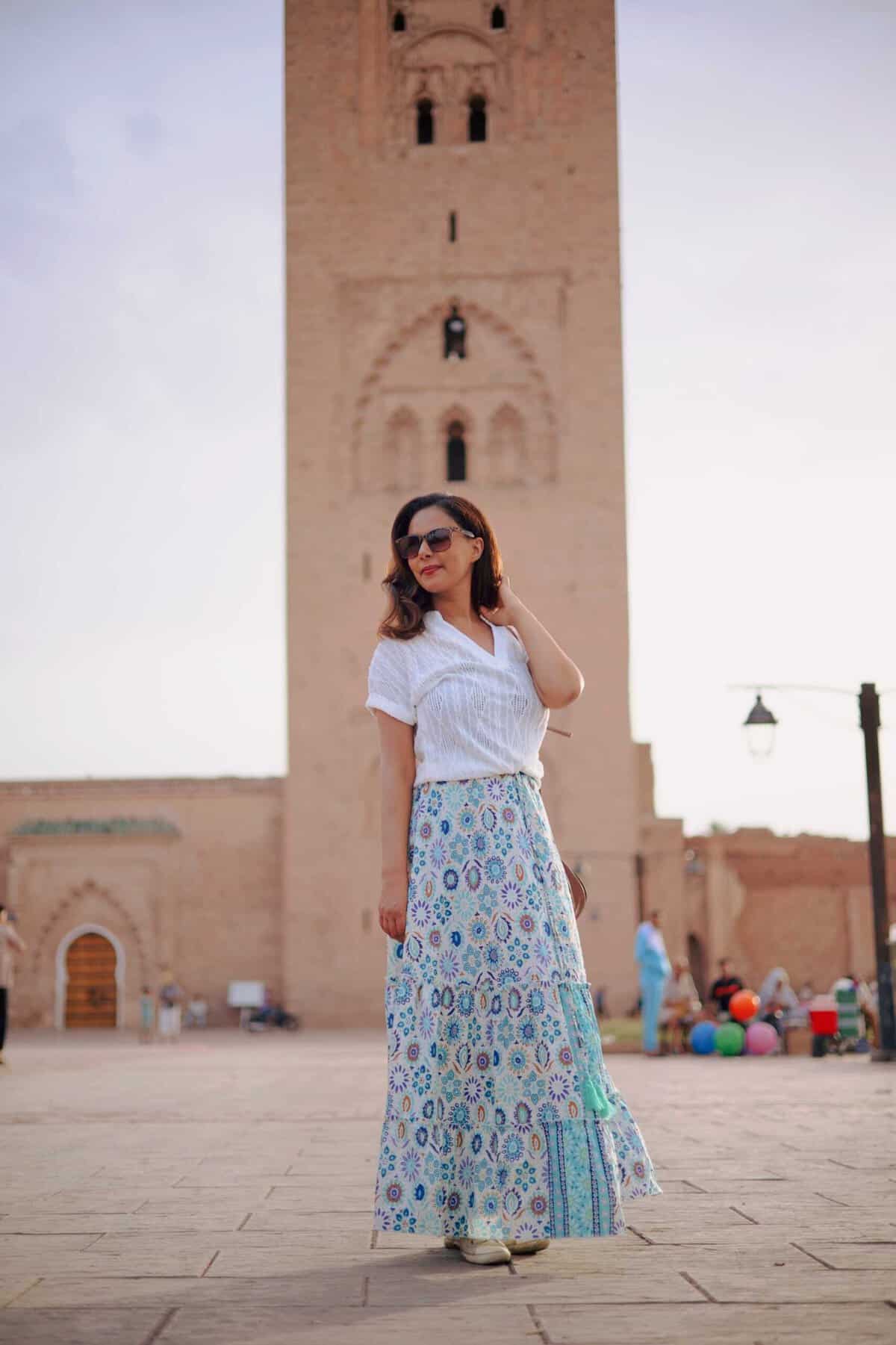 girl pausing in front of a tall pink mosque