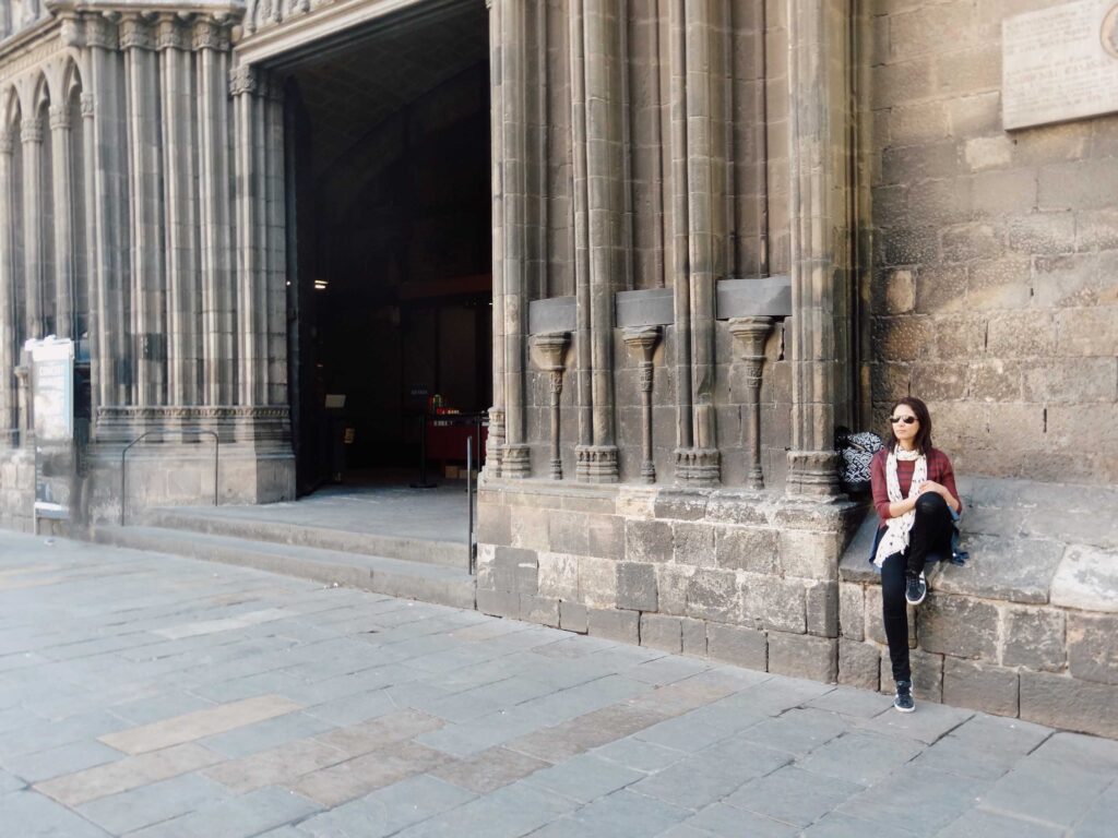 Girl sitting outside gothic building in Barcelona