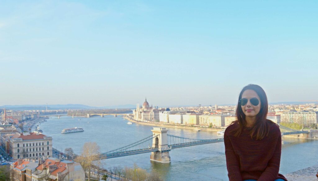 Girl sitting with a panoramic view of the Danube in Budapest