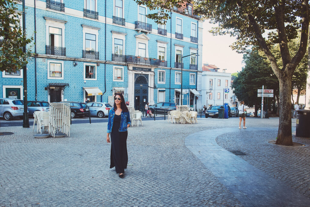 girl walking on cobbled pavements. Blue tiles behind