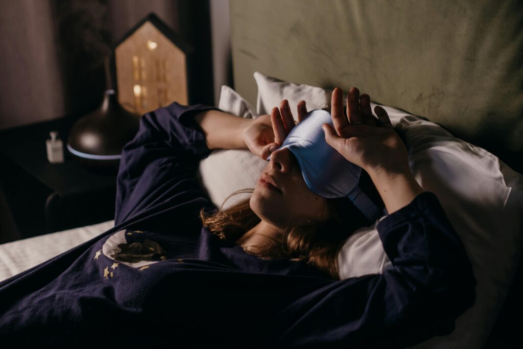 woman wearing a sleep mask in a dark room 